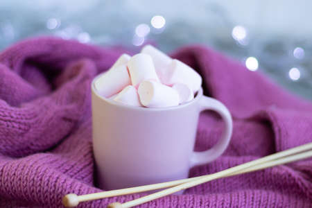 knitting needles, a cup of coffee with pink marshmallows.Christmas lightsの写真素材