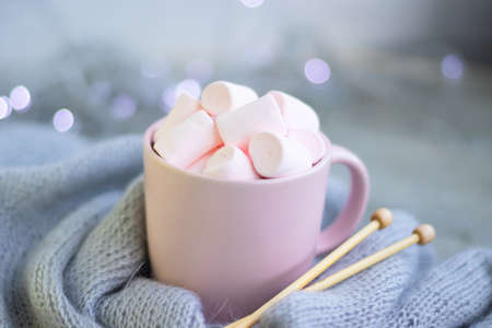 knitting needles, a cup of coffee with pink marshmallows.Christmas lights.の写真素材