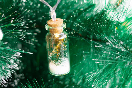 Christmas garland on the Christmas tree, in the form of a glass bottle inside the Christmas tree, the concept of Christmas and new year.の写真素材