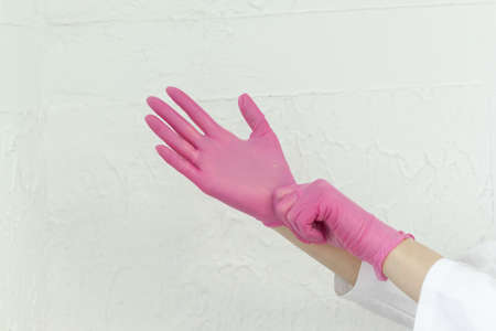 hands in pink rubber gloves on a white background.の写真素材