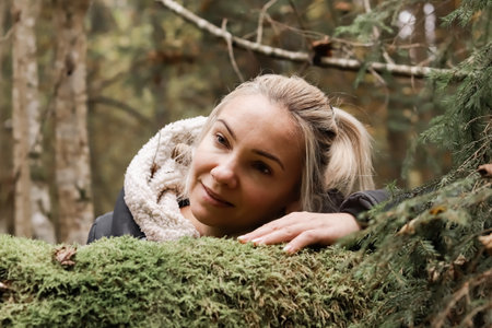 A nature lover woman hugs a tree trunk in the forest. green natural background. The concept of people who love nature and protect against deforestation, pollution or climate change.の写真素材