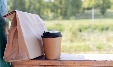 A paper coffee cup to take away with a lunch gift bag. Disposable mock-up packaging. Copy spaceの写真素材