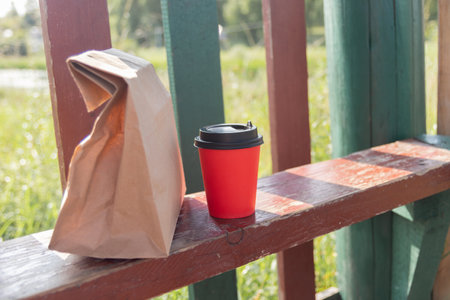 Takeaway paper coffee cup with a craft lunch bag Snack delivery service. Disposable mock-up packaging. Thanks for the donation. Minimumの写真素材