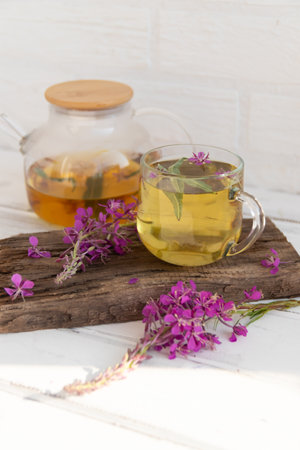 A drink (decoction) from the leaves and flowers of the medicinal plant ivan-tea (cypress, epilobium) in a mug. Traditional medicine, collection of useful herbs. Alternative medicineの写真素材