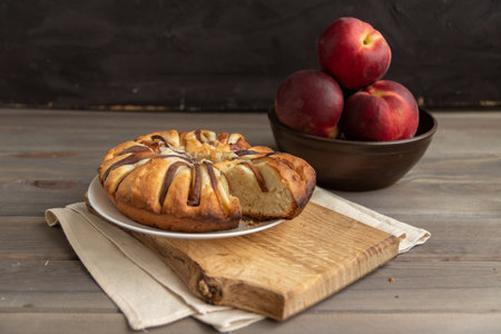 homemade peach pie on a wooden board on a black backgroundの写真素材