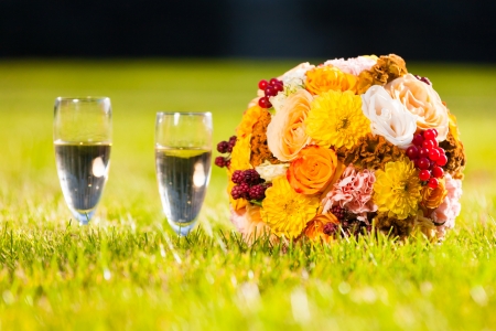 bouquet of beautiful flowers and two glasses on a holidayの写真素材
