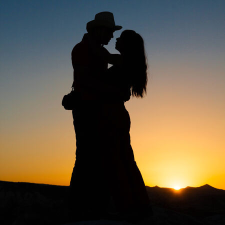 hug of two lovers on a background of a fiery sunsetの写真素材