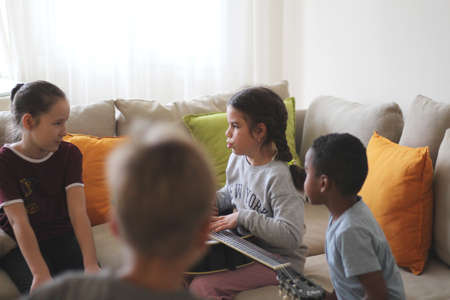 four different color kids are playing together in a room