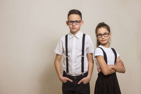 Portrait two schoolchildren with glasses over light background. School timing concept. Knowledge day. Space for textの写真素材