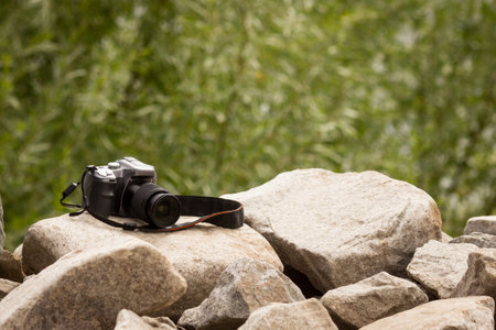 The camera lies on the stones close-up.photographic equipment in nature.photography training.