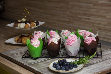 Colorful handmade cupcakes on the table in the kitchen.cupcakes decorated with cream close-up.sweets and desserts on a standの写真素材