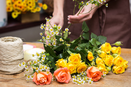 Girl florist makes bouquet.Flowers close-up the hands of florist.Florist cuts rose flowers with secateurs.pruning stems with secateurs.girl cut flowers with secateurs close-up. floristry courses.flower arrangement training.girl caring for flowersの写真素材