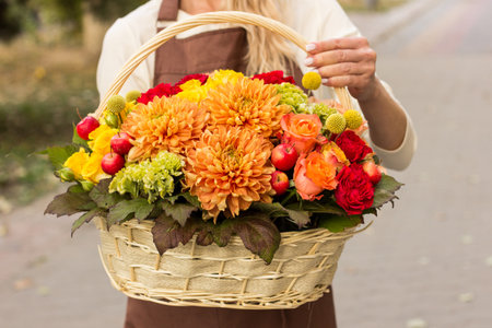 Girl florist holding basket of flowers her hands.flower composition.Floristry courses.photography with fresh flowers. sale of flowers flower shop.big basket with rosesの写真素材