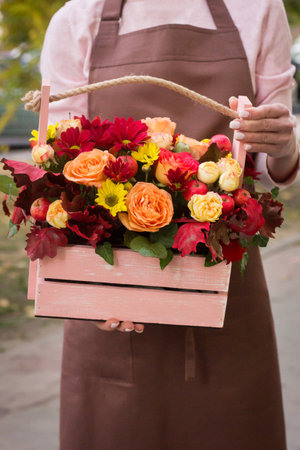Girl florist holding basket of flowers her hands.flower composition.Floristry courses.photography with fresh flowers. sale of flowers flower shop.big basket with rosesの写真素材