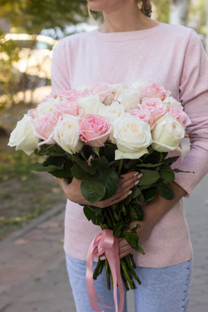 Girl holding a bouquet of pink roses close-upの写真素材
