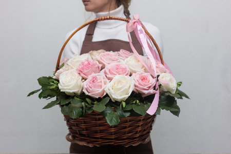 Girl florist holding basket of flowers her hands.flower composition.Floristry courses.photography with fresh flowers. sale of flowers flower shop.big basket with roses.flower sellerの写真素材