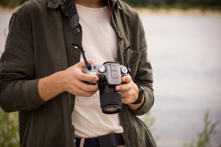 Camera close-up.Camera in hand.Photography training.Man looking at the camera.Camera photography lesson.Exploring camera settings.Man photographing nature.の写真素材