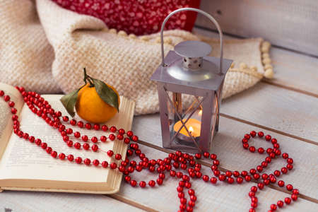 Christmas Lanterns, mandarin and red beads on wooden background.の写真素材