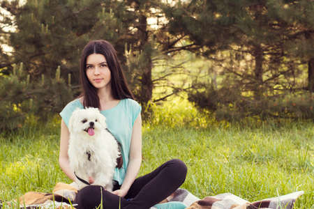 Beautiful girl with a young dog enjoying a beautiful day in the outdoors