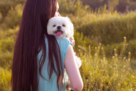 Beautiful brunette with a young dog enjoying a beautiful day outdoorsの写真素材