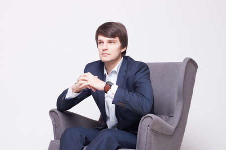 business man wearing suit  on  chair over white backgroundの写真素材
