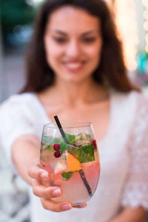 beautiful smiling woman drinking cold lemonade berry,  in a summer cafeの写真素材