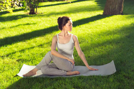 Young beautiful woman doing yoga in the park in the morning
