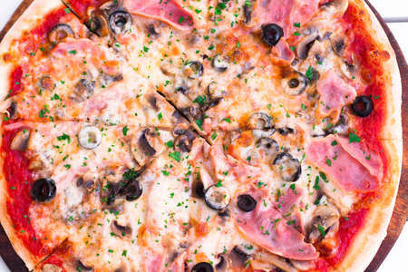 Delicious hot pizza with ham and mushrooms on wooden plate, close upの写真素材