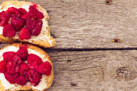 Toast with raspberry jam - homemade marmalade with fresh fruits from garden. All in rustic...