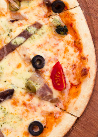 Hot pizza with meat, tomatoes and olivesの写真素材