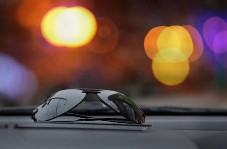 sunglasses on a background of city blured lightsの写真素材