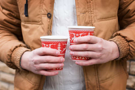 two cups of coffee in hand of a man