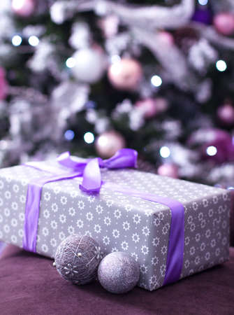 Stacks of Christmas presents under a Christmas tree with defocused lightsの写真素材