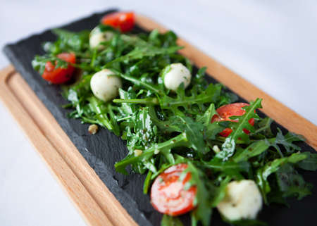 Tasty fresh Italian salad with quail eggs, arugula and tomato with olive oil. Close Upの写真素材