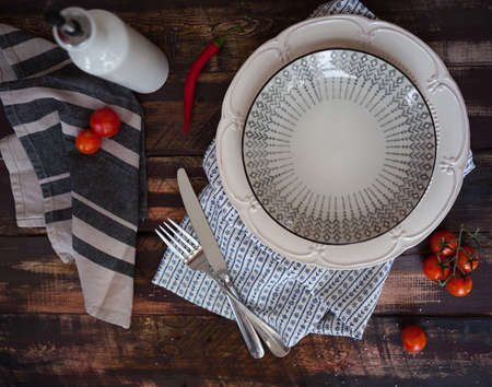White and gray empty plate and fork and knife on old wooden texture background