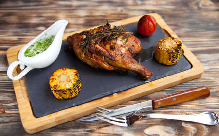 Tasty hot Grilled chicken lag and rosemary on wooden background.の写真素材