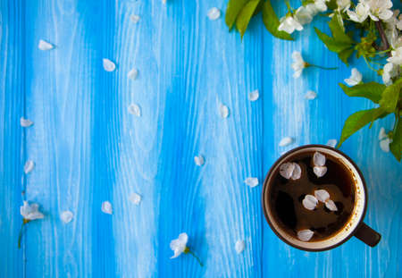 A cup of coffee on blue wood spring background. Selective focus