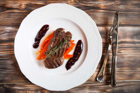 Delicious grilled meat with vegetable with rosemary on dark wooden background. Top viewの写真素材
