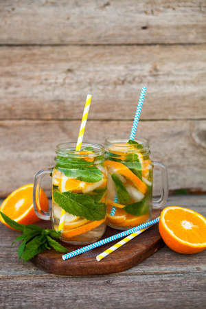 Cocktail. Orange juice with mint and ice on rustic wooden table