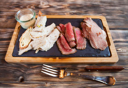 Cold meat plate and grissini bread sticks on wooden background. Top viewの写真素材
