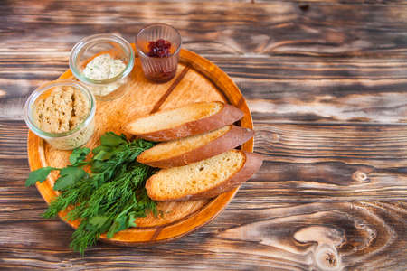 Smoked chicken and soft cheese spread, mousse, pate in a jar with crackers, on a wooden background. Top viewの写真素材