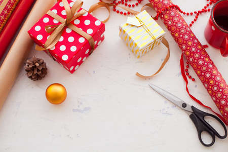 Wrapping Christmas gift - preparation. Accessories on wooden white desk, top viewの写真素材