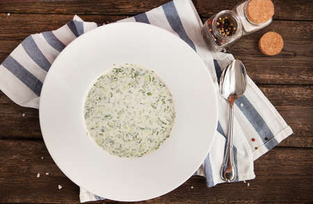 Cold summer soup with vegetables and yogurt (okroshka). Russian cuisine. Wood backgroundの写真素材