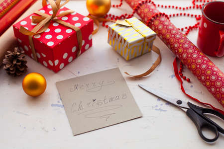 Wrapping Christmas gift - preparation. Accessories on wooden white desk, top viewの写真素材