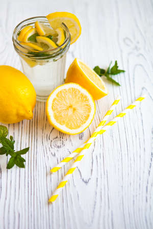 Lemon drink with fresh lemon and mint on white vintage wooden backgroundの写真素材