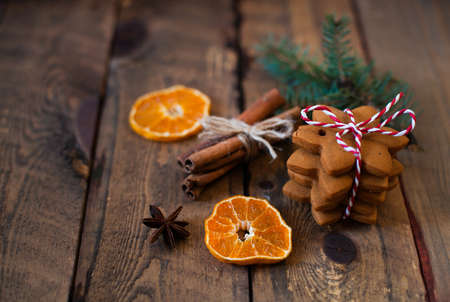 Christmas composition. Xmas cookies, tangerines, cinnamon, festive decoration, fir branches on dark old wooden background. Copy space.の写真素材