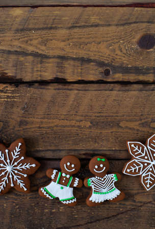 Christmas composition. Xmas cookies, Gingerbread man, tangerines, cinnamon, festive decoration, fir branches on dark old wooden background. Copy space.の写真素材