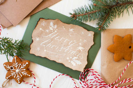 Christmas composition. Xmas cookies, Gingerbread man, ribbon, card, festive decoration, fir branches on white wooden background. Flat lay, top view, with copy space. Close Upの写真素材