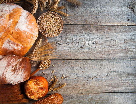 Assortment of baked bread on wooden table backgroundの写真素材