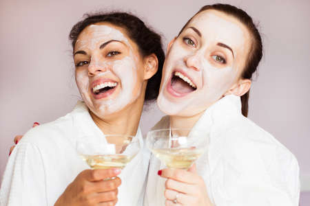 Smiling girlfriends with champagne in the spa salonの写真素材